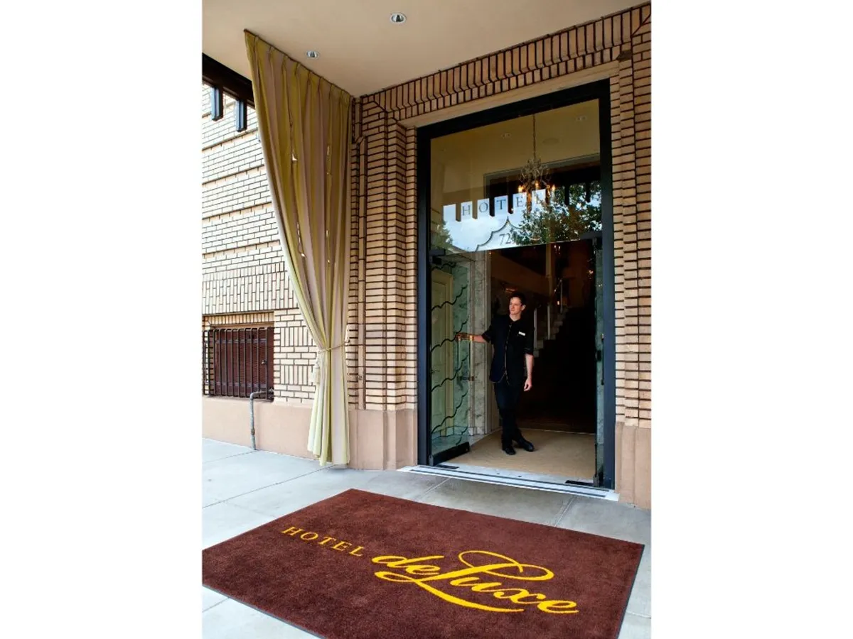 A glimpse into the upscale hotel lobby, featuring a staff member welcoming guests at the entrance. The interior exudes luxury and personalized service, underscoring the warm hospitality awaiting couples when they return from their city explorations.